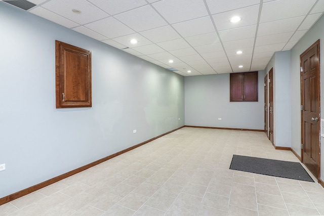 empty room featuring a paneled ceiling and light tile patterned floors