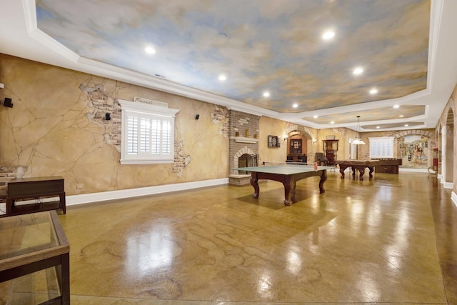 recreation room featuring arched walkways, a raised ceiling, a fireplace, and billiards