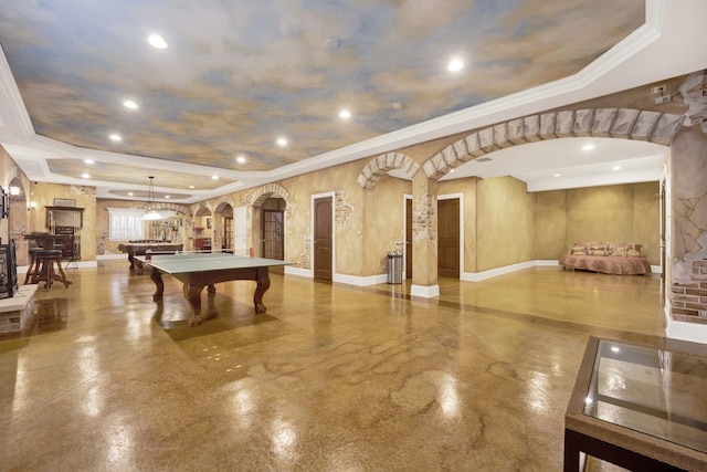 rec room featuring arched walkways, pool table, a tray ceiling, and ornamental molding