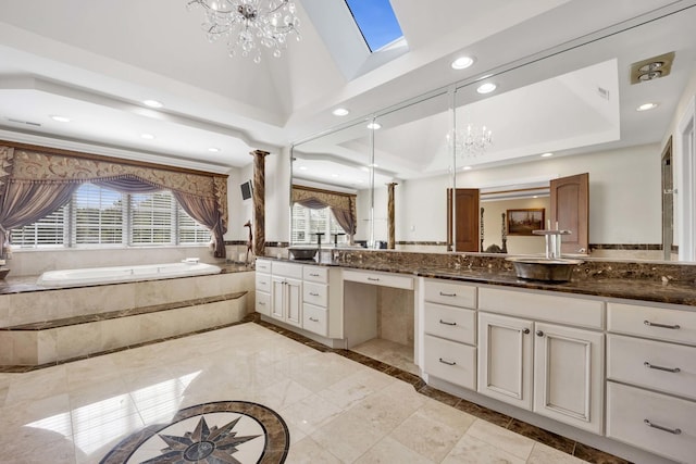 full bathroom with a chandelier, a raised ceiling, a bath, and vanity