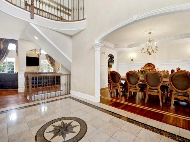 interior space with ornamental molding, decorative columns, baseboards, and an inviting chandelier