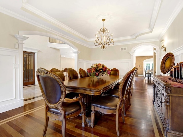 dining space with dark wood-type flooring, arched walkways, visible vents, and decorative columns