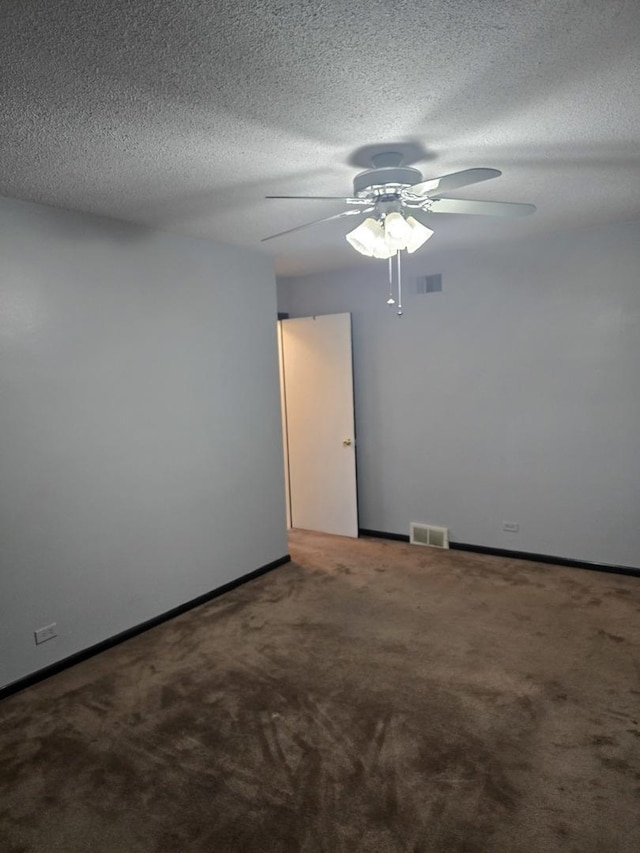 carpeted empty room featuring ceiling fan and a textured ceiling