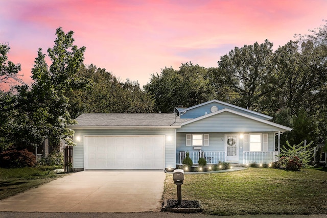 single story home featuring covered porch, a garage, and a yard