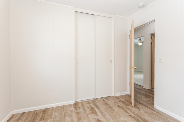 unfurnished bedroom featuring light hardwood / wood-style floors and a closet