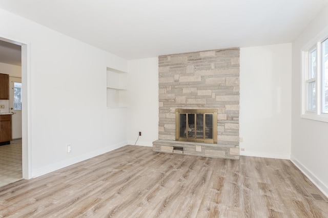 unfurnished living room featuring a fireplace and light hardwood / wood-style floors