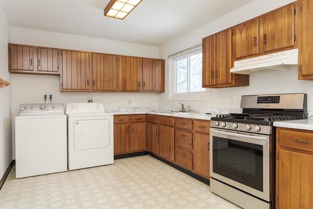 kitchen with washing machine and clothes dryer, stainless steel range with gas cooktop, and sink