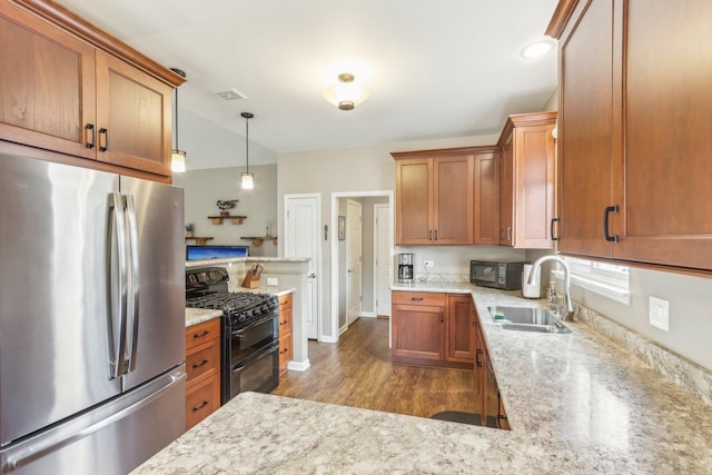 kitchen featuring sink, light stone counters, dark hardwood / wood-style flooring, decorative light fixtures, and black appliances