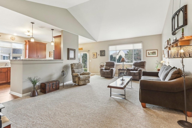 carpeted living room featuring sink and lofted ceiling