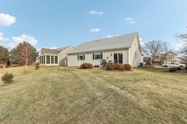 back of property with a yard, a sunroom, and central air condition unit