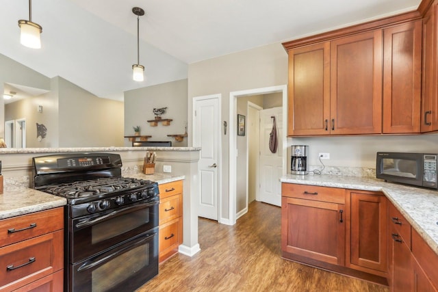 kitchen with decorative light fixtures, light hardwood / wood-style flooring, light stone counters, and black appliances