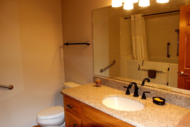 bathroom featuring toilet, vanity, and a shower with shower curtain