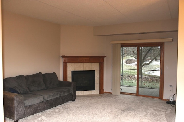 living room featuring light carpet and a tiled fireplace