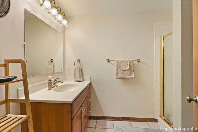 bathroom featuring tile patterned floors, a shower with door, and vanity