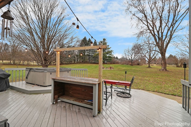 deck with a yard, grilling area, and a hot tub