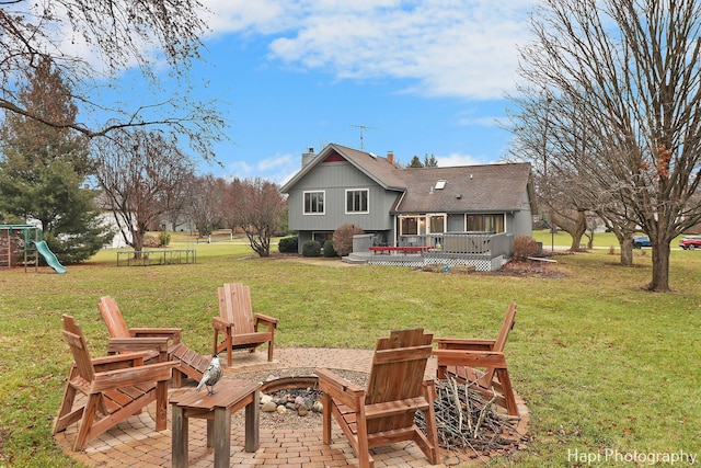 rear view of house featuring a lawn, a patio area, and an outdoor fire pit