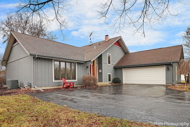 view of front facade featuring a garage and central AC unit