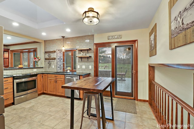 kitchen with pendant lighting, backsplash, sink, light tile patterned floors, and stainless steel appliances