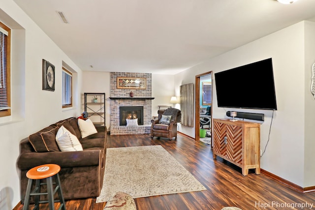 living room featuring a fireplace and dark wood-type flooring