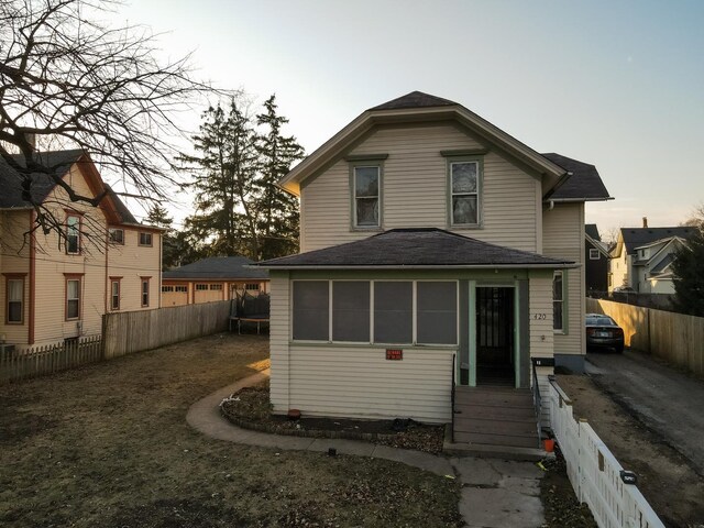 back house at dusk featuring a trampoline