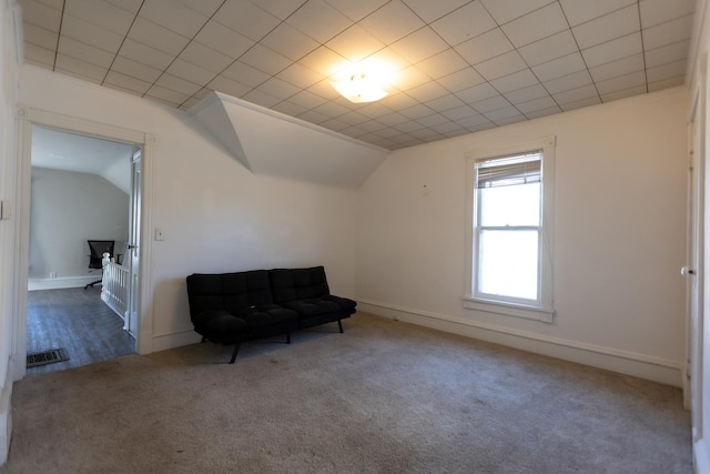 living area featuring carpet floors, lofted ceiling, visible vents, and baseboards