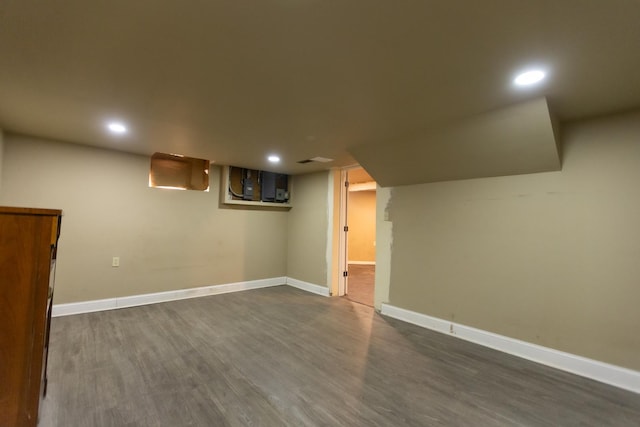 finished below grade area featuring dark wood-type flooring, recessed lighting, and baseboards