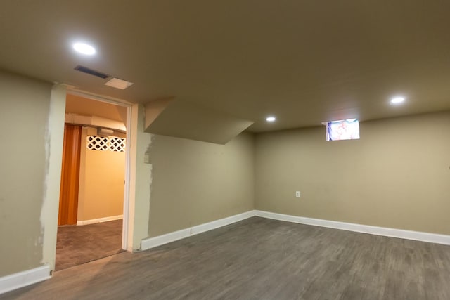 finished below grade area featuring recessed lighting, dark wood finished floors, visible vents, and baseboards