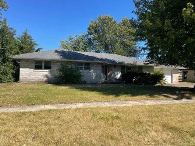 single story home featuring a front yard and a garage