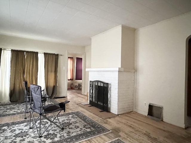 living room featuring hardwood / wood-style floors and a brick fireplace