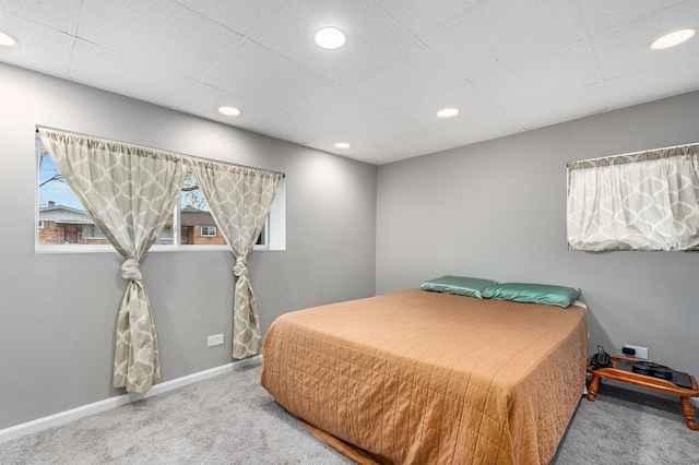 bedroom featuring carpet floors and a drop ceiling