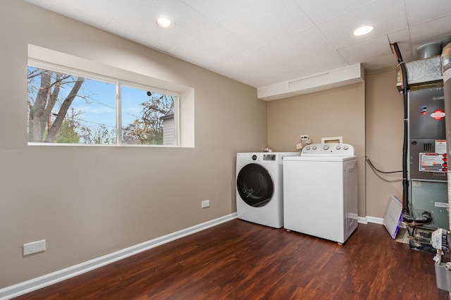 laundry room featuring washing machine and dryer, heating unit, and dark hardwood / wood-style floors