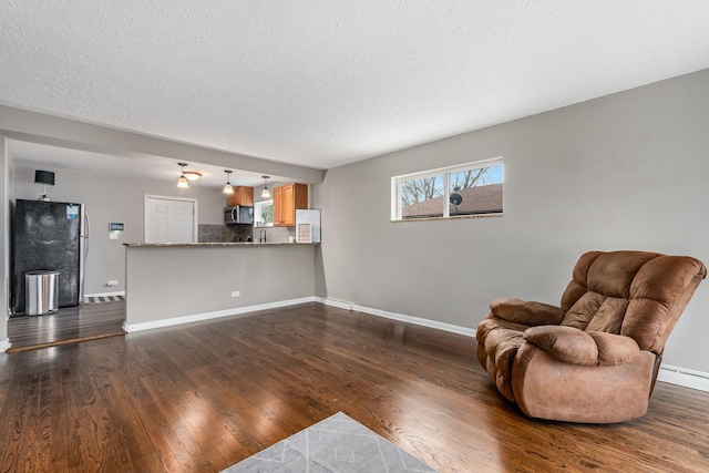 living area featuring a textured ceiling and dark wood-type flooring