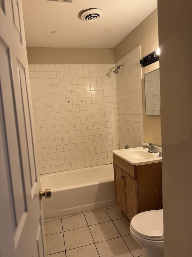 full bathroom featuring tile patterned floors, vanity, tiled shower / bath combo, and toilet