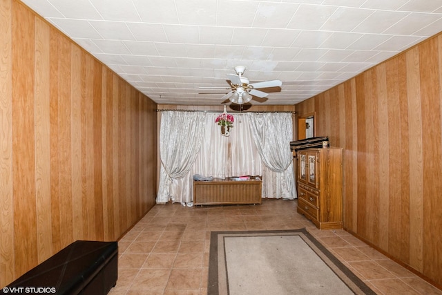 tiled spare room with ceiling fan and wooden walls