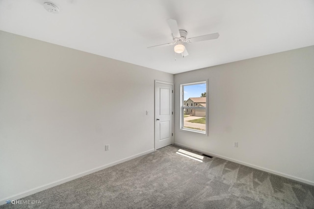 carpeted spare room with ceiling fan