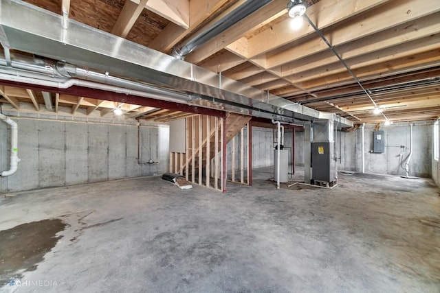 basement with electric panel, water heater, and heating unit