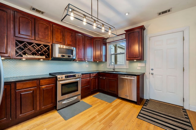3022 N Hamilton Ave, Chicago, IL 60618 - kitchen featuring dark countertops, visible vents, a sink, and appliances with stainless steel finishes