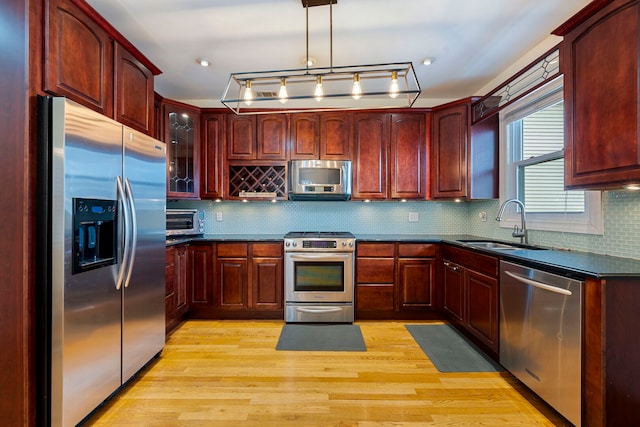 3022 N Hamilton Ave, Chicago, IL 60618 - kitchen with a sink, dark brown cabinets, dark countertops, light wood-style floors, and appliances with stainless steel finishes