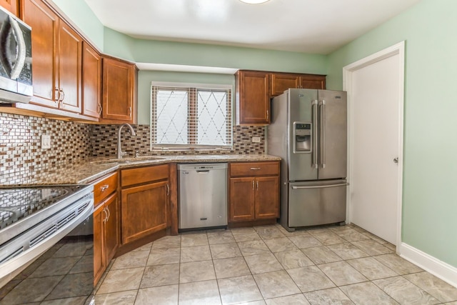 kitchen with backsplash, sink, dark stone counters, and appliances with stainless steel finishes