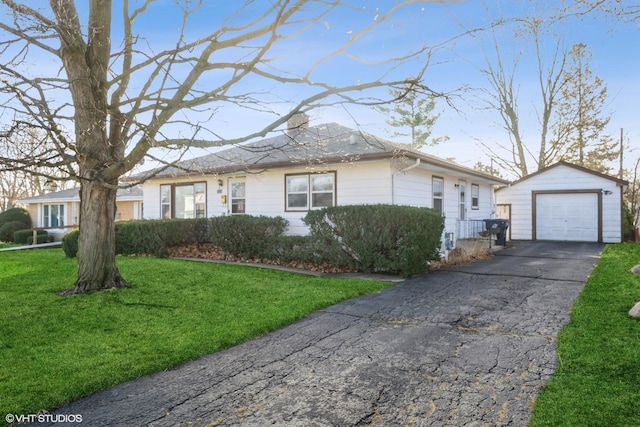 view of front facade with a garage, a front lawn, and an outdoor structure