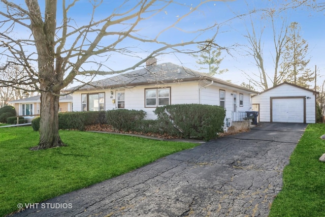 view of front of house with a front yard, an outdoor structure, and a garage