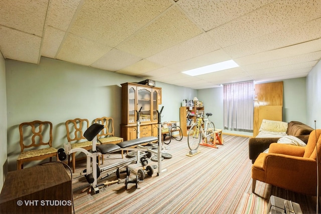 workout room featuring carpet and a drop ceiling