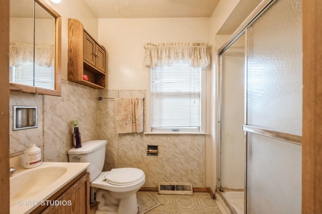 bathroom with a shower with door, vanity, and toilet