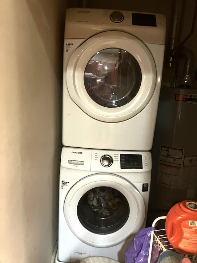 laundry room featuring stacked washer and dryer and water heater