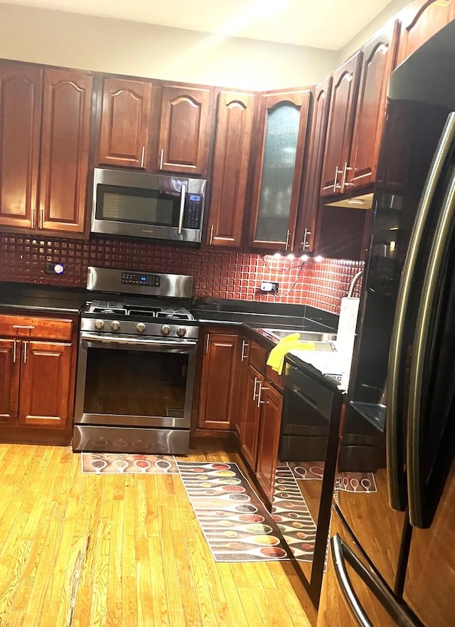 kitchen featuring decorative backsplash, stainless steel appliances, and light hardwood / wood-style floors