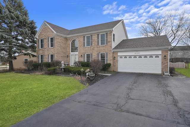 colonial-style house featuring a garage and a front yard