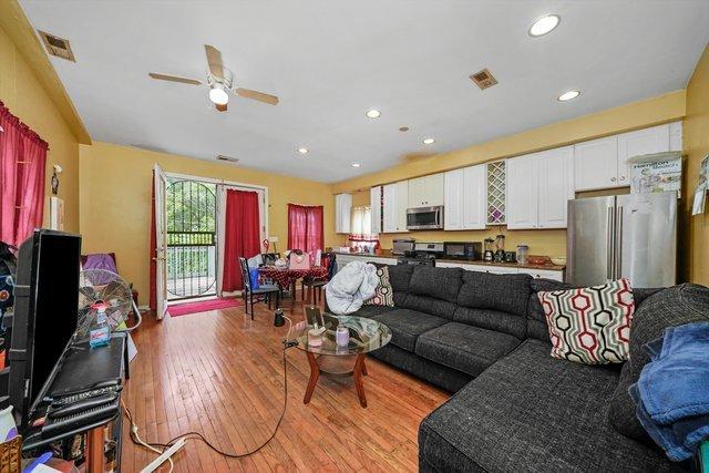 living room with ceiling fan and light hardwood / wood-style floors