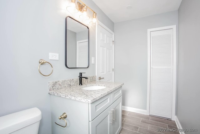 bathroom featuring hardwood / wood-style floors, vanity, and toilet