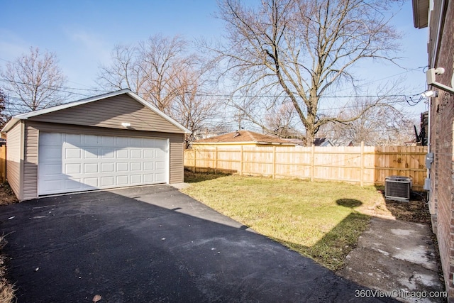 view of yard with a garage, central air condition unit, and an outbuilding