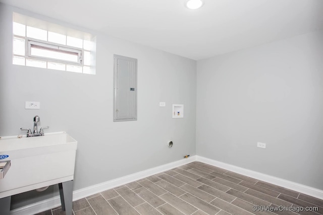 clothes washing area featuring hookup for a washing machine, laundry area, wood finish floors, baseboards, and electric panel